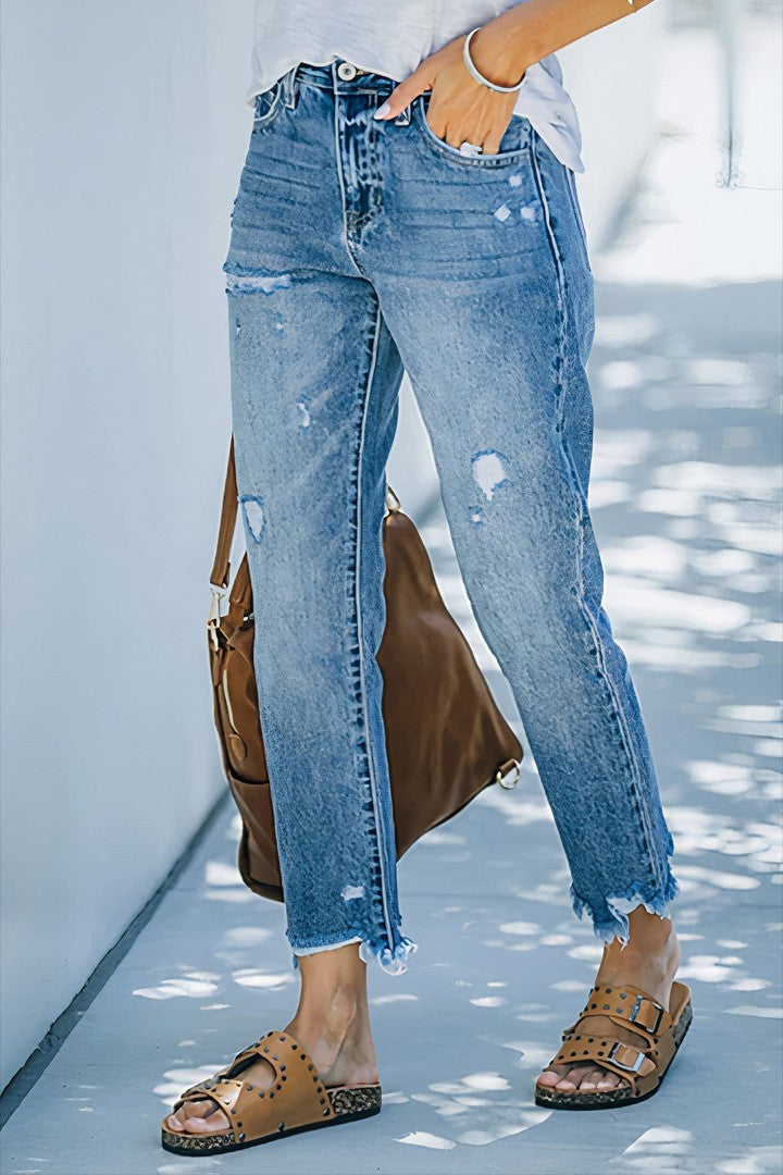 Jeans rasgados com bainha crua e cintura média e perna reta